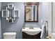 Charming bathroom features blue walls, decorative shelving, and a wood-framed mirror at 4810 W 102Nd Pl, Westminster, CO 80031