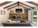 Vaulted ceiling living room with stone fireplace, wood beams, and sliding glass door at 4810 W 102Nd Pl, Westminster, CO 80031