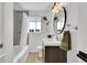 Updated bathroom with shower and tub combo, features updated lighting and modern vanity at 2725 S Monroe St, Denver, CO 80210