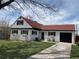 Charming single Gathering home with a well manicured lawn, red roof, black shutters, and a one car garage at 2725 S Monroe St, Denver, CO 80210