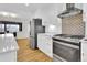 Modern kitchen with white cabinets, stainless steel appliances, stone countertops and backsplash at 2725 S Monroe St, Denver, CO 80210