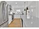 Modern kitchen featuring white cabinets, a stainless steel refrigerator, and a stone countertop island at 2725 S Monroe St, Denver, CO 80210