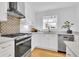 Bright kitchen with white cabinetry, stainless steel appliances, and a sleek, modern design at 2725 S Monroe St, Denver, CO 80210