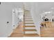 Bright stairway features hardwood floors and white trim, offering a fresh, modern look at 2725 S Monroe St, Denver, CO 80210