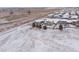 Winter aerial view of a residential neighborhood featuring snow-covered rooftops and open fields at 1523 Honeysuckle Ct, Brighton, CO 80601