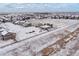 Aerial view of a neighborhood in winter, featuring single-Gathering homes, snow-covered yards, and open spaces at 1523 Honeysuckle Ct, Brighton, CO 80601