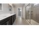 Bathroom featuring double vanity, tile floors, and a glass-enclosed shower with a tiled surround at 1523 Honeysuckle Ct, Brighton, CO 80601