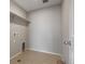 Functional laundry room with tile flooring, utility connections, and convenient overhead shelving at 1523 Honeysuckle Ct, Brighton, CO 80601