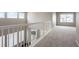 Upstairs carpeted loft space featuring windows, overlooking the staircase with bright natural light at 1523 Honeysuckle Ct, Brighton, CO 80601