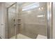 Walk-in shower features tile surround, glass door, and built-in shelves at 1523 Honeysuckle Ct, Brighton, CO 80601