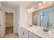 Bright bathroom featuring double sinks, quartz counters, and a glass enclosed shower at 13832 Honey Hush Trl, Parker, CO 80134