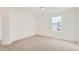 Spare bedroom featuring neutral carpeting, white walls, and a view overlooking the front at 13832 Honey Hush Trl, Parker, CO 80134
