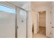 Tiled shower enclosure with a seamless glass door and a bright transom window at 13832 Honey Hush Trl, Parker, CO 80134