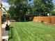 Green backyard featuring a well-manicured lawn, patio, and privacy fence at 6719 W 70Th Ave, Arvada, CO 80003