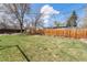 Spacious backyard with lush lawn, surrounded by a privacy fence and mature trees at 6719 W 70Th Ave, Arvada, CO 80003