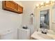 Bathroom with wood cabinets, decorative mirror, and well-maintained fixtures at 6719 W 70Th Ave, Arvada, CO 80003