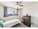 Cozy bedroom featuring a comfortable bed, wooden dresser, and a ceiling fan at 6719 W 70Th Ave, Arvada, CO 80003