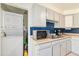 Kitchen featuring modern appliances and a washer and dryer at 6719 W 70Th Ave, Arvada, CO 80003