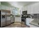 Well-equipped kitchen with stainless steel appliances and white cabinets at 15222 E Batavia Pl, Aurora, CO 80011