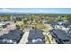 Aerial view of gray townhomes with green space, mountains, and commercial buildings at 157 Ambrose St, Erie, CO 80516