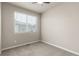 Neutral bedroom with a ceiling fan, large window, and carpeted floors at 157 Ambrose St, Erie, CO 80516