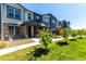 Beautiful townhome with manicured lawn, stone accents, and a welcoming covered entry at 157 Ambrose St, Erie, CO 80516