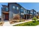 Attractive townhome with landscaping, stone accents, and a covered entry porch at 157 Ambrose St, Erie, CO 80516