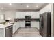 Bright kitchen with stainless steel appliances, white cabinetry, hard surface countertops, wood-look flooring, and sleek finishes at 157 Ambrose St, Erie, CO 80516