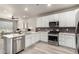 Open concept kitchen with stainless steel appliances, an island with hard surface countertops, and white cabinetry at 157 Ambrose St, Erie, CO 80516
