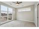 Bright bedroom featuring a ceiling fan, plush carpet, and a large window offering plenty of natural light at 3500 S Corona St # 409, Englewood, CO 80113