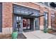 Apartment building entrance with glass doors, a modern awning, and decorative planters flanking the entry at 3500 S Corona St # 409, Englewood, CO 80113