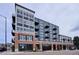 Modern apartment building featuring a brick and gray facade, multiple balconies, and street-level retail at 3500 S Corona St # 409, Englewood, CO 80113