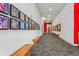 Long hallway with artwork lining the walls and wooden benches on either side at 3500 S Corona St # 409, Englewood, CO 80113