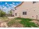 A grassy backyard with a mix of grass and dirt patches, a small patio, and the house's exterior at 4152 Netherland St, Denver, CO 80249