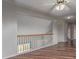 Upstairs hallway featuring laminate wood flooring, a ceiling fan and railing overlooking the stairs at 4152 Netherland St, Denver, CO 80249