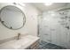 Stylish bathroom with modern shower, granite vanity, and round mirror at 8265 W 90Th Pl, Broomfield, CO 80021