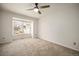 A bright bedroom features neutral walls and carpet with a large window and modern ceiling fan at 8265 W 90Th Pl, Broomfield, CO 80021