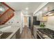 Bright kitchen with stainless steel appliances, granite countertops, and a view of the stairway at 8265 W 90Th Pl, Broomfield, CO 80021