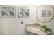 Stylish half bathroom with granite vanity, round mirror, and elegant decor at 8265 W 90Th Pl, Broomfield, CO 80021