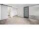 Spacious bedroom with sliding barn doors, carpet flooring, closet, and entry door at 8265 W 90Th Pl, Broomfield, CO 80021