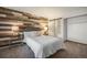 Bedroom featuring a wood accent wall, plush bedding, and ensuite bathroom at 8265 W 90Th Pl, Broomfield, CO 80021