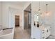 Modern bathroom showcasing a walk-in shower, soaking tub, double vanity with light fixtures, and sleek tiling at 8648 Carneros Ct, Parker, CO 80138