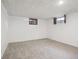 Finished basement featuring neutral carpet, white walls and paneled ceiling, with windows at 2251 Braun Dr, Golden, CO 80401