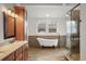 Bathroom featuring a soaking tub, glass-enclosed shower, and decorative tile work at 841 Niagara St, Denver, CO 80220