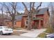 Front view of a brick two-story home with mature trees at 841 Niagara St, Denver, CO 80220