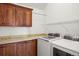 Convenient laundry room featuring custom cabinets, granite countertops, and a washer and dryer set at 841 Niagara St, Denver, CO 80220