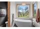Bathroom with modern fixtures, a soaking tub, and a large window overlooking the landscape at 25350 Ridge Way, Golden, CO 80401