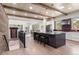 Open concept kitchen flows into living area, featuring an island with seating and a brick accent wall at 25350 Ridge Way, Golden, CO 80401