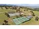 Aerial view showcasing multiple tennis courts, surrounded by lush greenery and scenic mountain views at 25350 Ridge Way, Golden, CO 80401
