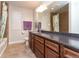 Bathroom featuring a long countertop with cabinets, a shower with curtains, and two windows at 1665 Avery Way, Castle Rock, CO 80109